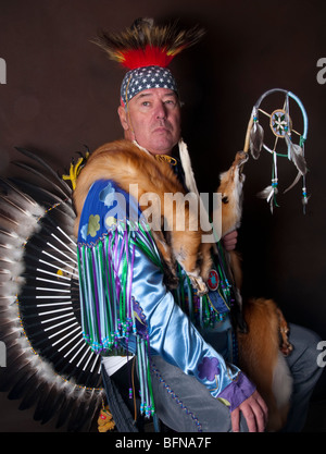 Native American Indian maschio in full regalia con eagle feather trambusto e drappeggiati in fox pellicce azienda dream catcher Foto Stock