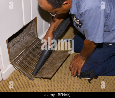 ARLINGTON, VIRGINIA, STATI UNITI D'AMERICA - Uomo vaccums sporco lavoro condotto nella vecchia casa. Foto Stock