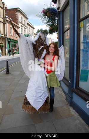 La gente colorata in Glastonbury High Street Somerset Inghilterra Foto Stock