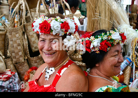 Due donne indigene circondato da loro fatte a mano cestini di paglia che sono in vendita nel mercato di Papeete. Foto Stock