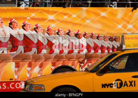 Taxi passa un autobus turistico con un annuncio pubblicitario per il Radio City Music Hall Christmas Spectacular con il Rockettes in New York Foto Stock