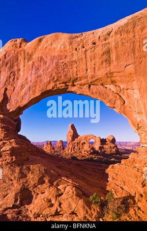 La luce del mattino sulla torretta Arch attraverso la finestra del Nord, il Parco Nazionale di Arches, Utah Foto Stock