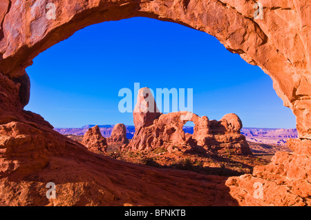 La luce del mattino sulla torretta Arch attraverso la finestra del Nord, il Parco Nazionale di Arches, Utah Foto Stock