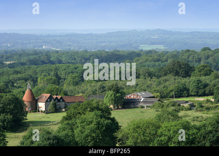 Vista in lontananza oast House nel Kent weald, preso dalla strada Foto Stock