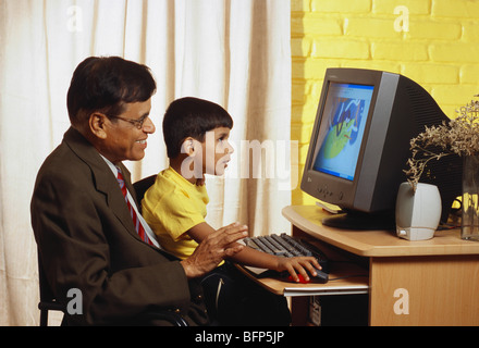 Nipote di bambino indiano che mostra computer al nonno ; india ; asia ; MR 448,560 Foto Stock