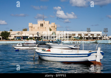 Barche sul lungomare vicino al fort del sultano Qaitbay presso il Porto orientale della città di Alessandria, Egitto Foto Stock