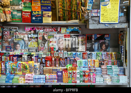 Colorato di fronte news stand peddling evasione di vario genere sul lower Broadway nel centro di Manhattan a New York City Foto Stock