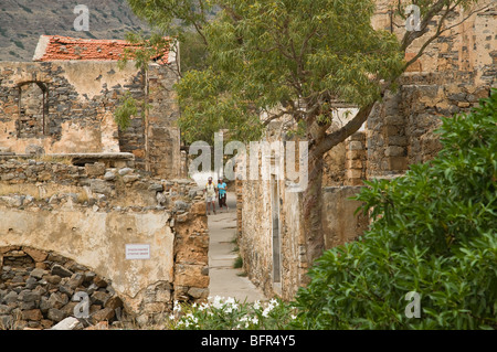 Dh Spinalonga AGIOS NIKOLAOS Grecia CRETA i turisti a piedi attraverso strade di ex lebbrosario vacanza in coppia Foto Stock