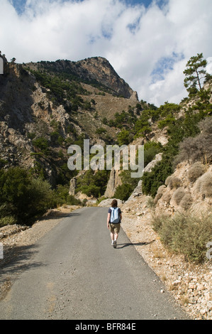 Dh area Metaxochori IERAPETRA Grecia CRETA donna turistico backpacker camminando giù Dikti cretese strada di montagna Foto Stock