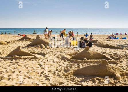 Famiglie che le sculture di sabbia di delfini su Boscombe Beach, Bournemouth Dorset. Regno Unito. Foto Stock