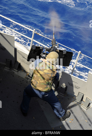 Gunners Mate sparare un 0,50 Caliber machine gun a bordo guidato-missili cruiser USS Vella Gulf. Foto Stock