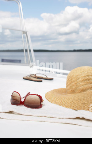 Occhiali da sole e cappello e Flip Flop in barca Foto Stock