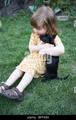 Bambina giocare con un cucciolo Foto Stock