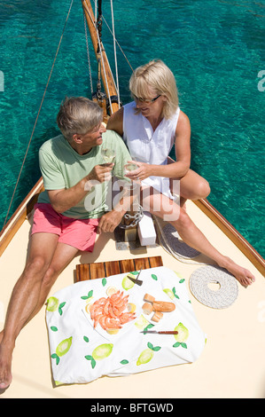 Una coppia senior picnic mentre la vela Foto Stock