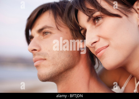 Paio di godersi il tramonto sulla spiaggia Foto Stock