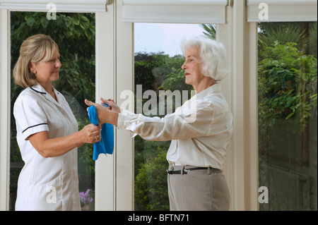 L'infermiera aiutando la donna con gli esercizi Foto Stock