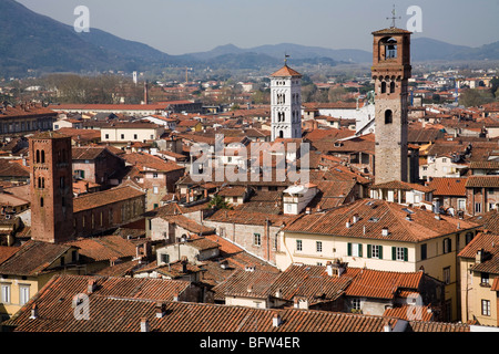 Una vista sui tetti di Lucca per le montagne distanti che mostra la Torre delle Ore Foto Stock