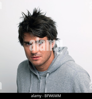 Giovane uomo in grigio top con cappuccio Foto Stock