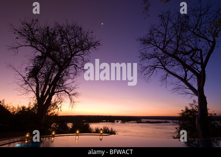 Il River Club Lodge, tramonto sul fiume Zambesi e nello Zambia. Foto Stock