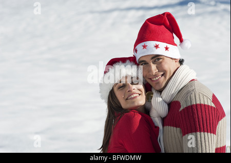 Matura in abito di Natale abbracciando Foto Stock