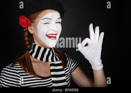 Ritratto di una giovane donna vestito come un mime isolate su sfondo nero Foto Stock