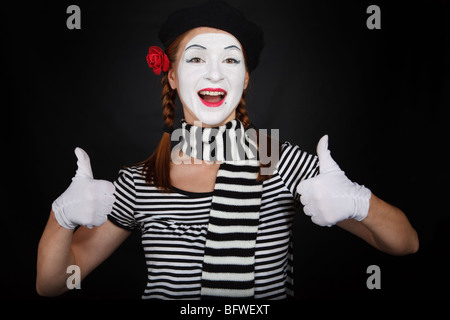 Ritratto di una giovane donna vestito come un mime isolate su sfondo nero Foto Stock