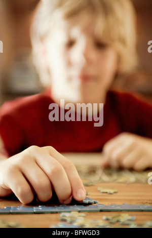 Un ragazzo lavorando su un puzzle Foto Stock