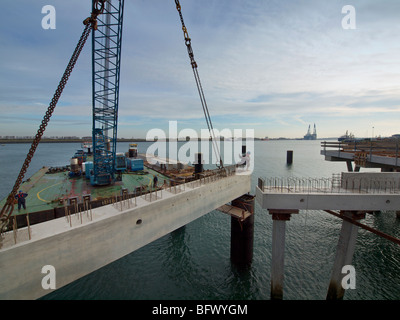 Grandi gru galleggiante il sollevamento di un blocco di calcestruzzo in posizione durante la creazione di una stazione docking pier per una grande nave di petrolio, Botle Foto Stock