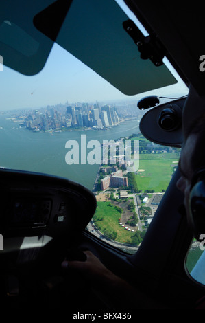 Un pilota di aereo leggero Cessna 172 sorvolano Governors Island, Manhattan e East River, New York City, Stati Uniti d'America Foto Stock