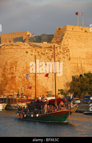 Cipro del Nord. Un caicco vela in Kyrenia porto alla fine della giornata con il castello dietro. 2009. Foto Stock