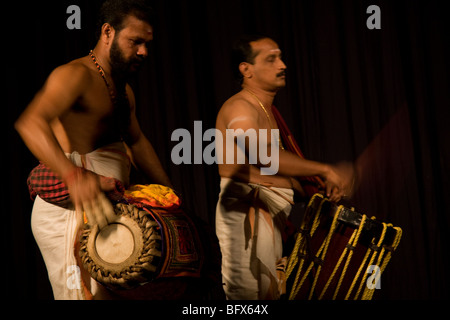 I percussionisti accompagnare un Kathakali play, una forma antica del sud teatro indiano eseguito in un teatro a Trivandrum, Kerala. Foto Stock