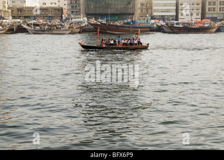 Lavoratori prendere una tradizionale barca Abra attraversando il Dubai Creek di Dubai Foto Stock