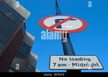 British cartelli stradali che indicano nessun indicatore di direzione destra e nessun caricamento da 7am fino a mezzanotte Foto Stock