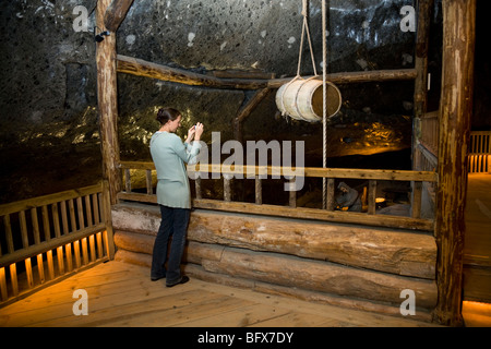 Turistica prendendo una fotografia / snap shot in una camera sotterranea della Miniera di Sale di Wieliczka. Vicino a Cracovia in Polonia. Foto Stock