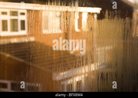 La formazione di condensa su una finestra di uso domestico in British suburbia presto su una mattina di novembre. Foto Stock