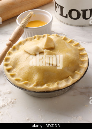 La pasta frolla la torta in una teglia per torte tuorlo d'uovo spazzolato Foto Stock