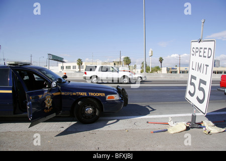 Nevada Highway Patrol Trooper stato veicolo tramite il segnale di limite di velocità a Las Vegas. Foto Stock