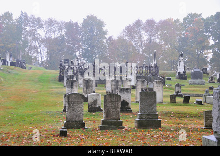 Pioggia e nebbia accentua la spooky, mossy lapidi in un vecchio cimitero nel Maine, Stati Uniti d'America. Foto Stock