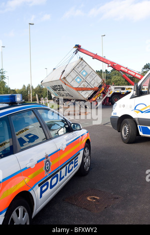 Autocarro ribaltata essendo salvato da un carrello di salvataggio nel Leicestershire, in Inghilterra con auto della polizia sul sito Foto Stock