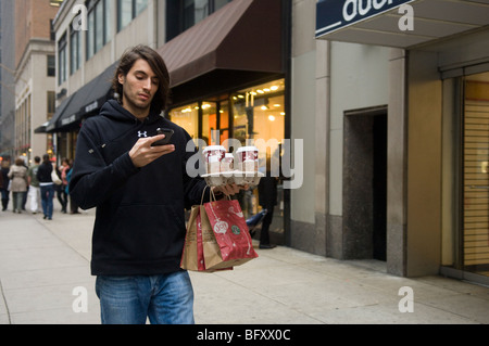 Un cliente porta estrarre caffè Starbucks sulla Fifth Avenue a Midtown a New York Foto Stock