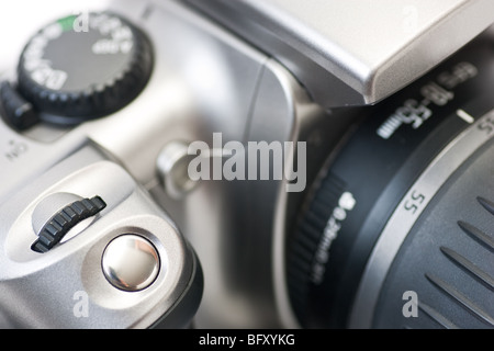 Un primo piano della parte superiore di una fotocamera reflex digitale, con focus su il pulsante otturatore, isolato su bianco. Foto Stock