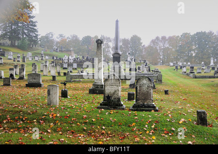 In autunno la pioggia e nebbia accentua la spooky, lapidi di muschio in un vecchio cimitero nel Maine, Stati Uniti d'America. Foto Stock