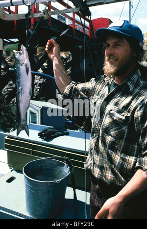 Gange, Saltspring Island, BC British Columbia, Canada, pescatore con pesce in vendita su commerciale pesca barca ormeggiata al mercato Foto Stock