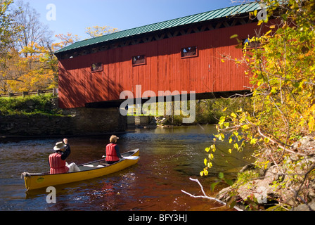 Giovane canoa verso un ponte coperto in West Arlington Vermont - USA Foto Stock