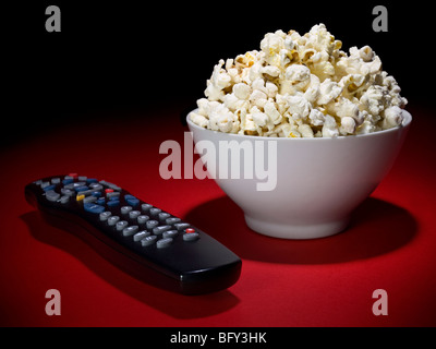 Una ciotola di popcorn e un telecomando pronto per divertimento. Foto Stock