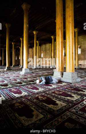 Uomo musulmano dormire in Jamia Masjid moschea, Srinagar Kashmir, India. Foto Stock