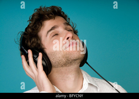 Uomo che ascolta le cuffie con gli occhi chiusi Foto Stock