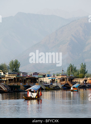 Taxi acqueo (shikara) vicino casa tradizionale barche su dal lago in Srinagar Kashmir, India. Foto Stock