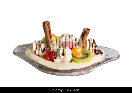 Banana Split con kiwi, fragole, ribes, physalis, scaglie di cioccolato e crema e salsa al cioccolato in un piatto di vetro. Foto Stock