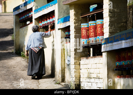 Pellegrino tibetano la filatura ruote della preghiera e la realizzazione di una kora (seremonial cerchio) intorno al Dalai Lama e la sua residenza in Dharamsala, India. Foto Stock